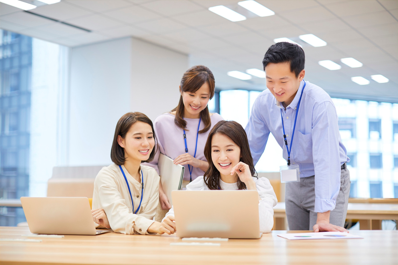 パソコンを囲んで一緒に作業する社員